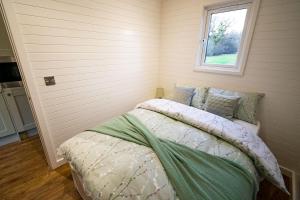 雷克瑟姆Luxury Pod Cabin in beautiful surroundings Wrexham的一间卧室设有一张床和一个窗口
