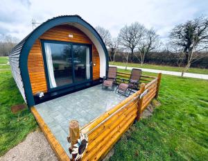 雷克瑟姆Luxury Pod Cabin in beautiful surroundings Wrexham的凉亭配有两把椅子和庭院