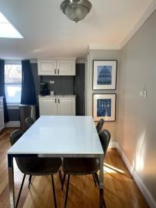 华盛顿Large studio apartment steps from the US Capitol!的一间配备有白色桌椅的用餐室