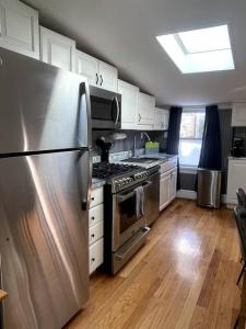 华盛顿Large studio apartment steps from the US Capitol!的厨房配有不锈钢冰箱和白色橱柜