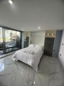 奥尔德伯里Mara Boutique Apartments 1的一张大白色的床,位于一个设有大窗户的房间