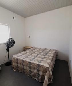 巴拉杜斯科凯鲁斯Casa de Praia Em Aracaju,Se的一间带风扇的客房内一张床的卧室