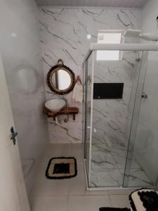 巴拉杜斯科凯鲁斯Casa de Praia Em Aracaju,Se的带淋浴、镜子和盥洗盆的浴室