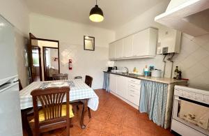 FreiriaPortuguese village apartment - Casa Martins No.54的一间带桌子的厨房和一间带白色橱柜的厨房