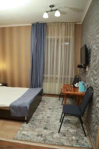 塞米伊VIP Mini Hotel的卧室配有1张床、1张桌子和1把椅子