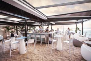 巴拿马城JW MARRIOT的海滩上的餐厅,配有白色的椅子和桌子