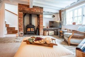 伍德布里奇The Pink Cottage, Blaxhall的带沙发和壁炉的客厅