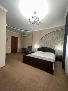 塞米伊VIP Mini Hotel的一间卧室配有一张大床和一个吊灯。