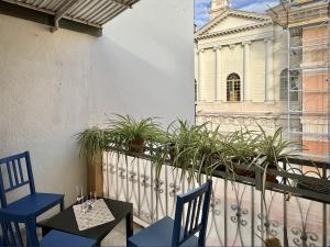 因佩里亚La casa fra la storia e il mare的阳台配有两把椅子和一张桌子,公寓大楼