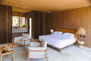 圣米格尔-杜斯米拉格里斯Mahré Hotel & Spa的一间卧室配有一张大床和一把椅子