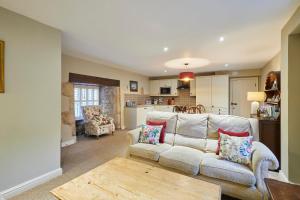 EasingtonHost & Stay - Tithe Barn Cottages的客厅配有沙发和桌子