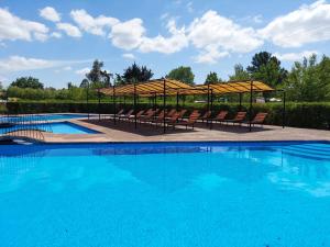 El ManzanoCabanas Turismo Don Ambrosio的一个带椅子和遮阳伞的大型游泳池