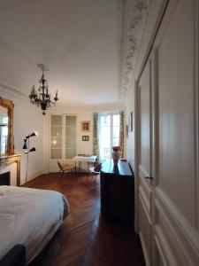 巴黎Chambre spacieuse - Trocadéro的卧室配有1张床、1张桌子和1把椅子