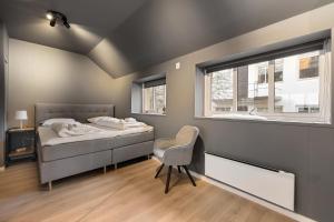 卑尔根Homerentals l 120sqm Mid-central - King beds - 500Mbps WI-FI的卧室配有床、椅子和窗户。