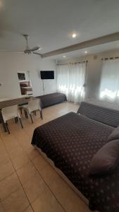 布兰卡港Apartamentos Güemes - Monoambientes的一间卧室配有一张床和一张带钢琴的书桌