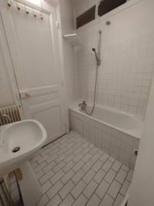 巴黎Chambre spacieuse - Trocadéro的白色的浴室设有水槽和浴缸。