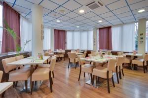 里尔Brit Hotel Lille Centre的一间设有白色桌椅的用餐室