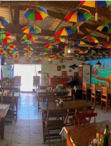 嘎林海斯港Pousada Porto Marola的餐厅拥有五颜六色的伞,挂在天花板上
