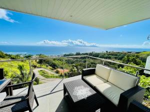 普纳奥亚Tahiti Moetama Cosy Lodge - VILLA ITI的阳台配有沙发,享有海景。