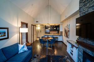 坎莫尔The Eagle Suite at Stoneridge Mountain Resort的客厅配有蓝色的沙发和桌子
