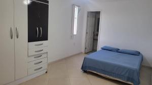 里约达欧特拉斯Pousada Pé na Areia的一间白色卧室,配有一张床和一个梳妆台