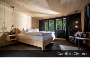 格施塔德Hotel Arc-en-ciel Gstaad的一间卧室配有一张床、一把椅子和一张沙发