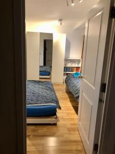伦敦Room 1 or 2 ppl near EXCEL, O2, Canary Wharf - London的一间设有两张床的房间和一扇通往卧室的门