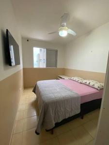 巴拉那州蓬塔尔Lindo Apto com vista para o Mar!的一间卧室配有一张带粉色毯子的床