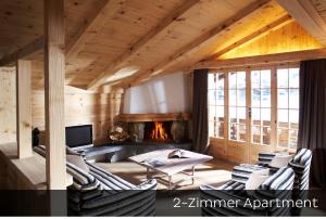 格施塔德Hotel Arc-en-ciel Gstaad的客厅配有椅子和壁炉