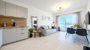 里沃Apartamenty Sun & Snow Pelikan的厨房以及带沙发和桌子的客厅。