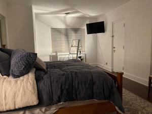 圣克劳德The Brower House的卧室配有一张床铺,墙上配有电视