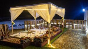 努瓦克肖特Complexe Hôtelier Sabah的夜间海滩帐篷下的餐桌