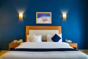 达哈布达哈布特罗皮泰绿洲度假村的一间卧室配有一张带蓝色墙壁的大床
