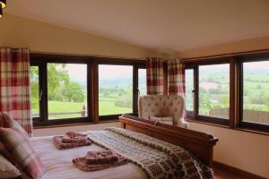 Llanrhaeadr-ym-MochnantThe Retreat的一间卧室配有一张带椅子的床和窗户