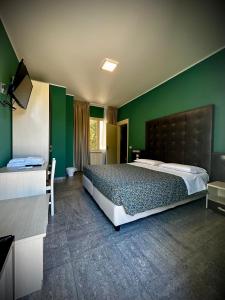 托莱港阿尔博尔格意大利酒店的一间卧室设有一张大床和绿色的墙壁