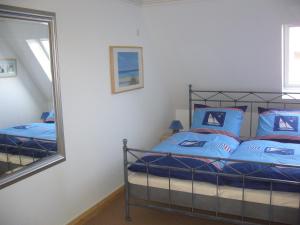 里斯特Lichtis Hues的一间卧室配有一张带蓝色枕头和镜子的床