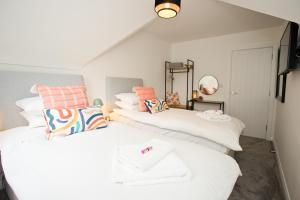 伯恩茅斯Stylish 2 Bedroom Apt - Parking - 5 Mins walk to Beach的配有白色和橙色枕头的客房内的两张床