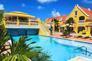 棕榈滩阿姆斯特丹庄园海滩度假酒店的黄色房子前面的游泳池