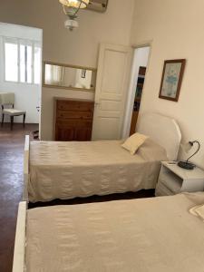 梅塞德斯Casa 1 habitacion的一间卧室配有两张床和一张带台灯的桌子