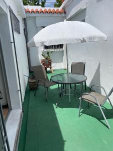 梅塞德斯Casa 1 habitacion的庭院配有桌椅和遮阳伞。