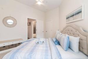 夏洛特Cozy Apartment with WiFi的白色卧室配有一张带蓝色枕头的大床