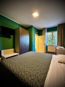 托莱港阿尔博尔格意大利酒店的一间卧室设有一张带绿色墙壁的大床