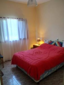 拉法尔达Encantadora Casa con parque的一间卧室设有红色的床和窗户。