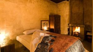 圣斯特凡诺·迪塞斯西克斯坦堤欧艾尔伯格迪富索酒店的带壁炉的客房内的一间卧室配有一张床