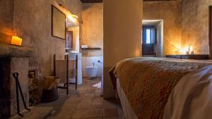 圣斯特凡诺·迪塞斯西克斯坦堤欧艾尔伯格迪富索酒店的一间卧室配有一张床,浴室设有浴缸