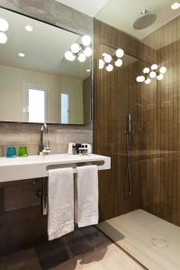 瓦伦西亚万邵科隆46酒店的浴室配有盥洗盆、淋浴和毛巾