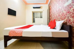 斋浦尔Collection O Hotel Rajwada Palace的一间卧室配有一张带红色枕头的大床