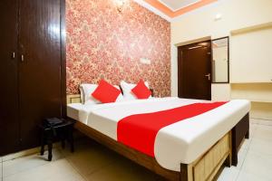 斋浦尔Collection O Hotel Rajwada Palace的一间卧室配有一张带红色和白色床单的大床