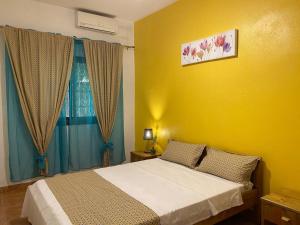 PamandziTropical House的一间卧室设有一张床和黄色的墙壁