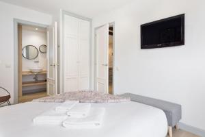 巴奎伊拉-贝莱特Luderna - Apartamento con terraza Bonaigua B1 Joanchiquet的白色的卧室设有床铺和墙上的电视